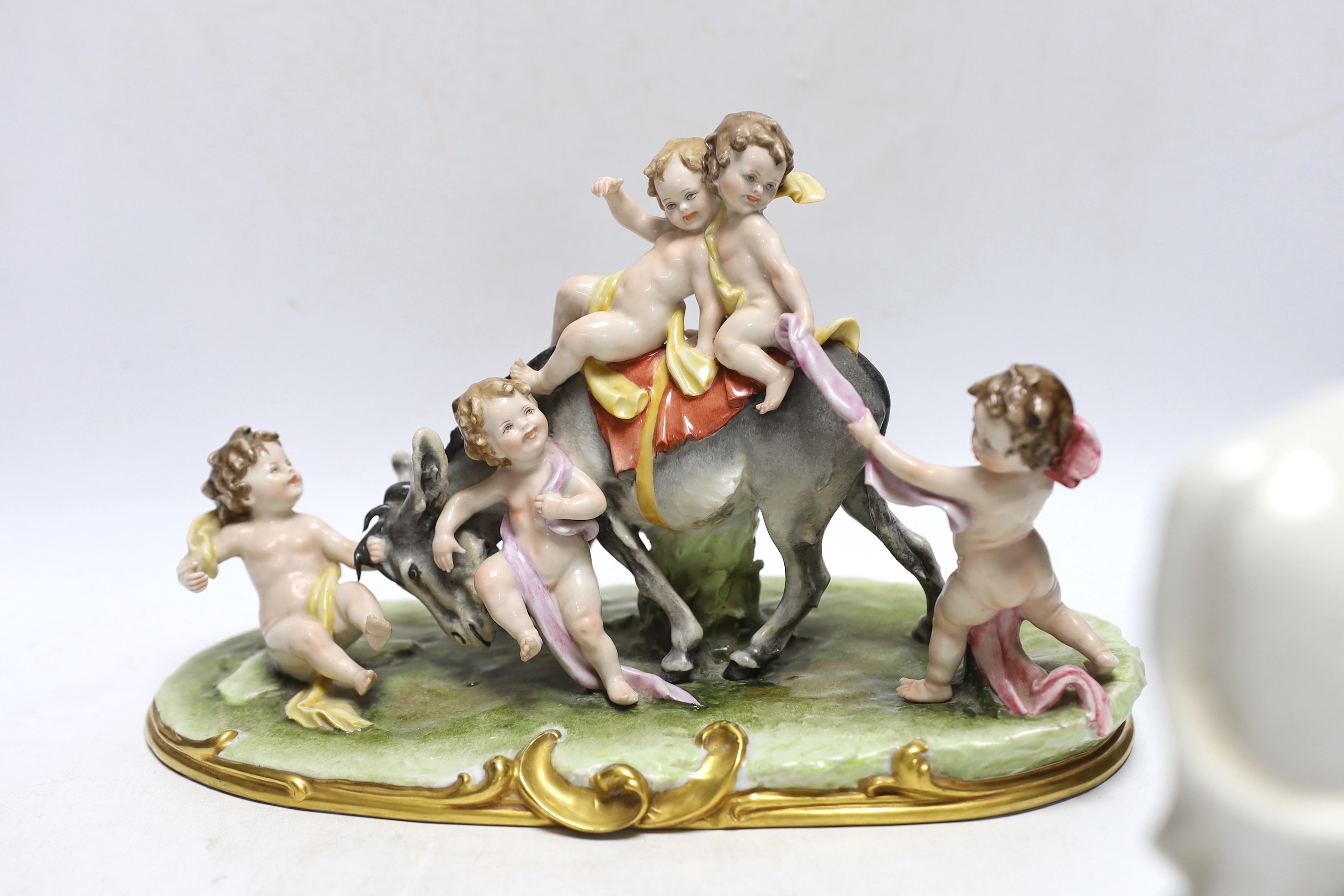 A pair of 19th century Staffordshire cow groups and an Italian donkey and cherub group, tallest 20.5cm